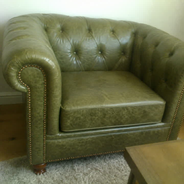 Close da Poltrona Chesterfield Verde Esmeralda mostrando o capitonê e o cravejado de tachas douradas