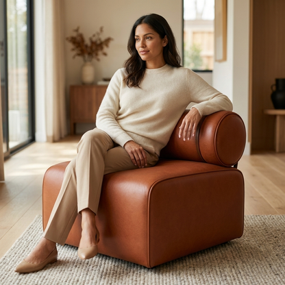 Mulher sentada em um módulo do Sofá Modular Terracota, em sala com aparador e vaso de flores secas