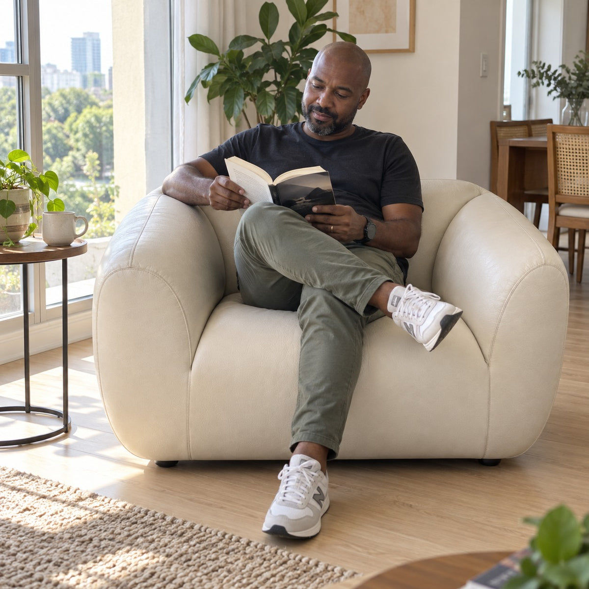 Poltrona Ventura Off White em Couro Naturale Premium — pessoa lendo — ambientação ilustrativa