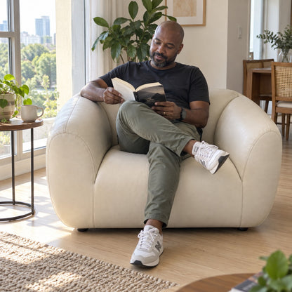 Poltrona Ventura Off White em Couro Naturale Premium — pessoa lendo — ambientação ilustrativa