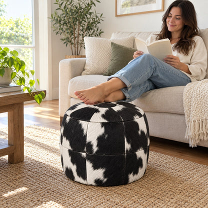 Puff Pipa Malhado Preto e Branco em Couro Bovino com Pelo 40x40cm — lifestyle com pessoa usando o puff em ambiente residencial claro