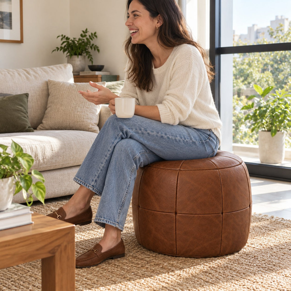Puff Pipa Tabaco em Couro Natural Premium 40x40cm — lifestyle com pessoa usando o puff em ambiente residencial claro