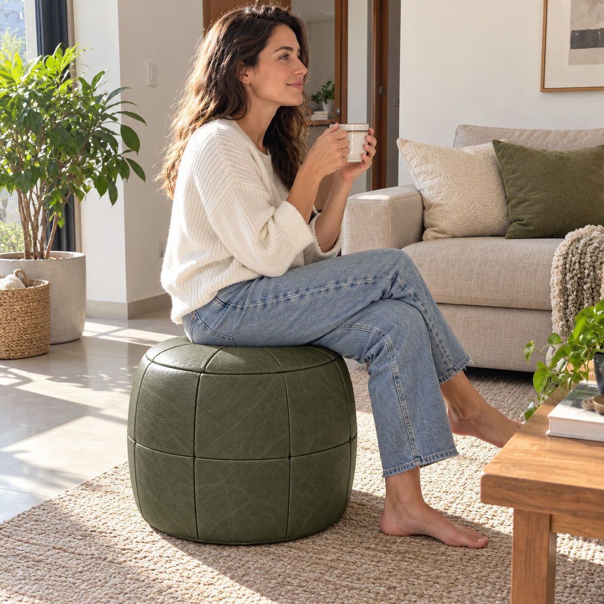 Puff Pipa Verde Esmeralda em Couro Natural Premium 40x40cm — lifestyle com pessoa usando o puff em ambiente residencial claro
