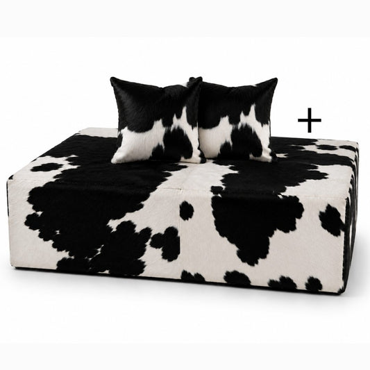 Puff de couro preto e branco com as duas almofadas do conjunto