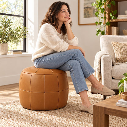 Puff Pipa Caramelo em couro natural premium — Pessoa usando o puff junto à poltrona
