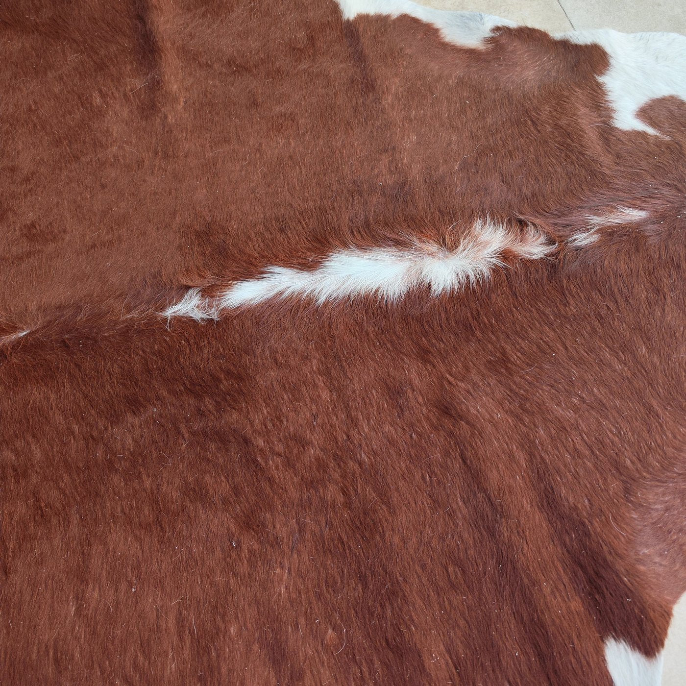 Tapete de couro de boi Vermelho e Branco Pelo Alto VB886 — detalhe do acabamento artesanal